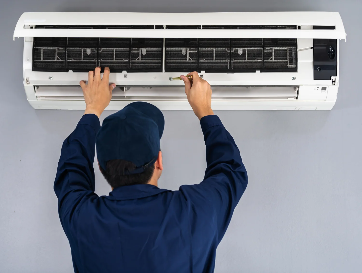 Technician cleaning wall-mounted air conditioner filters